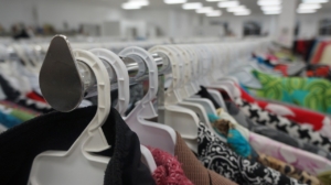 Many different kinds of clothes on a rack at a thrift store