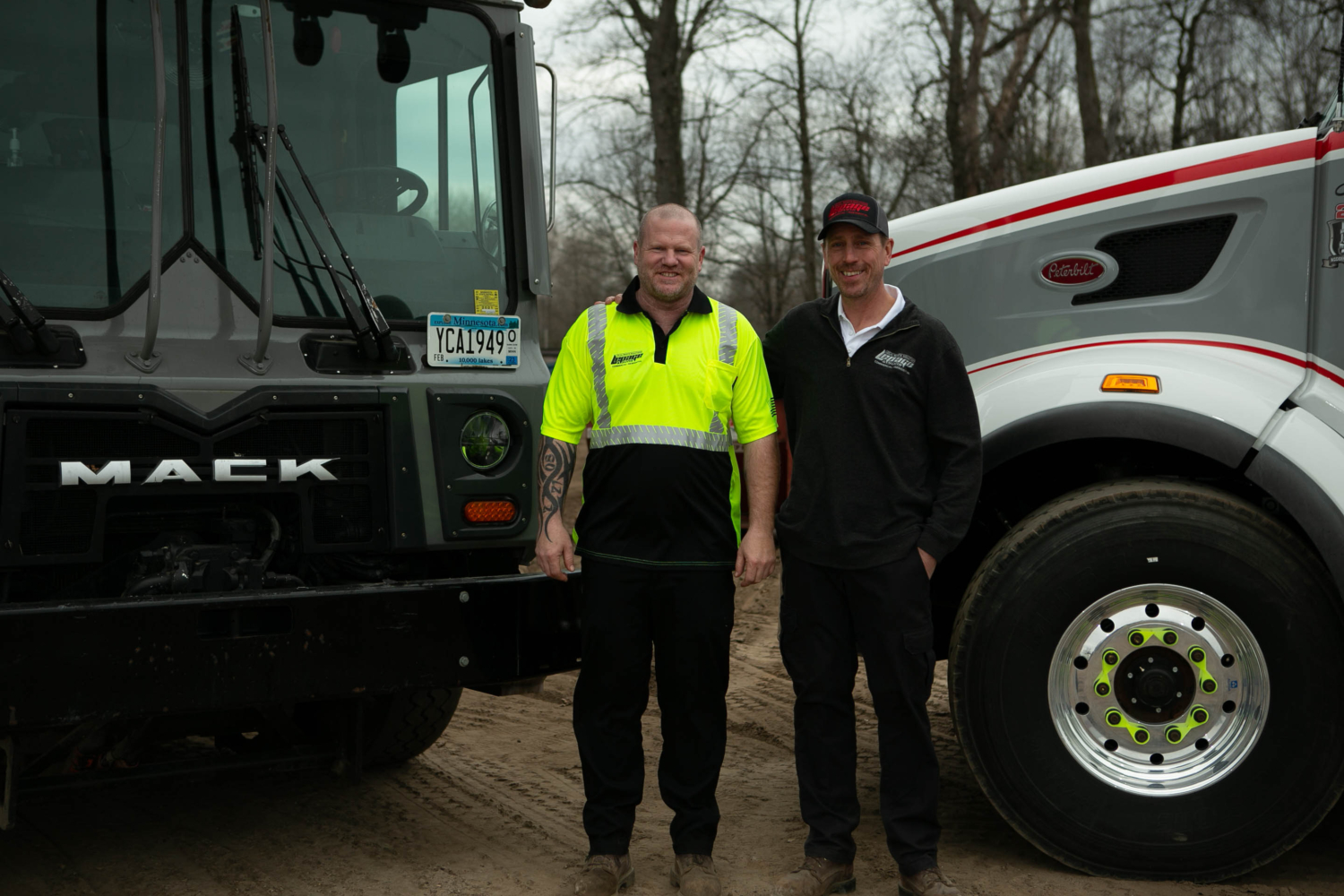 Owner of the local trash pick up company smiling with an employee