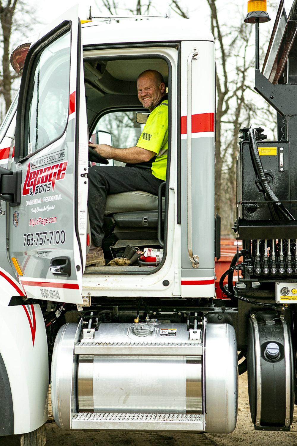 LePage Staff in the driver's seat of a lePage Waste Management truck